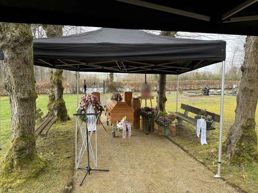 Trauerfeier im Freien unter einem Pavillon